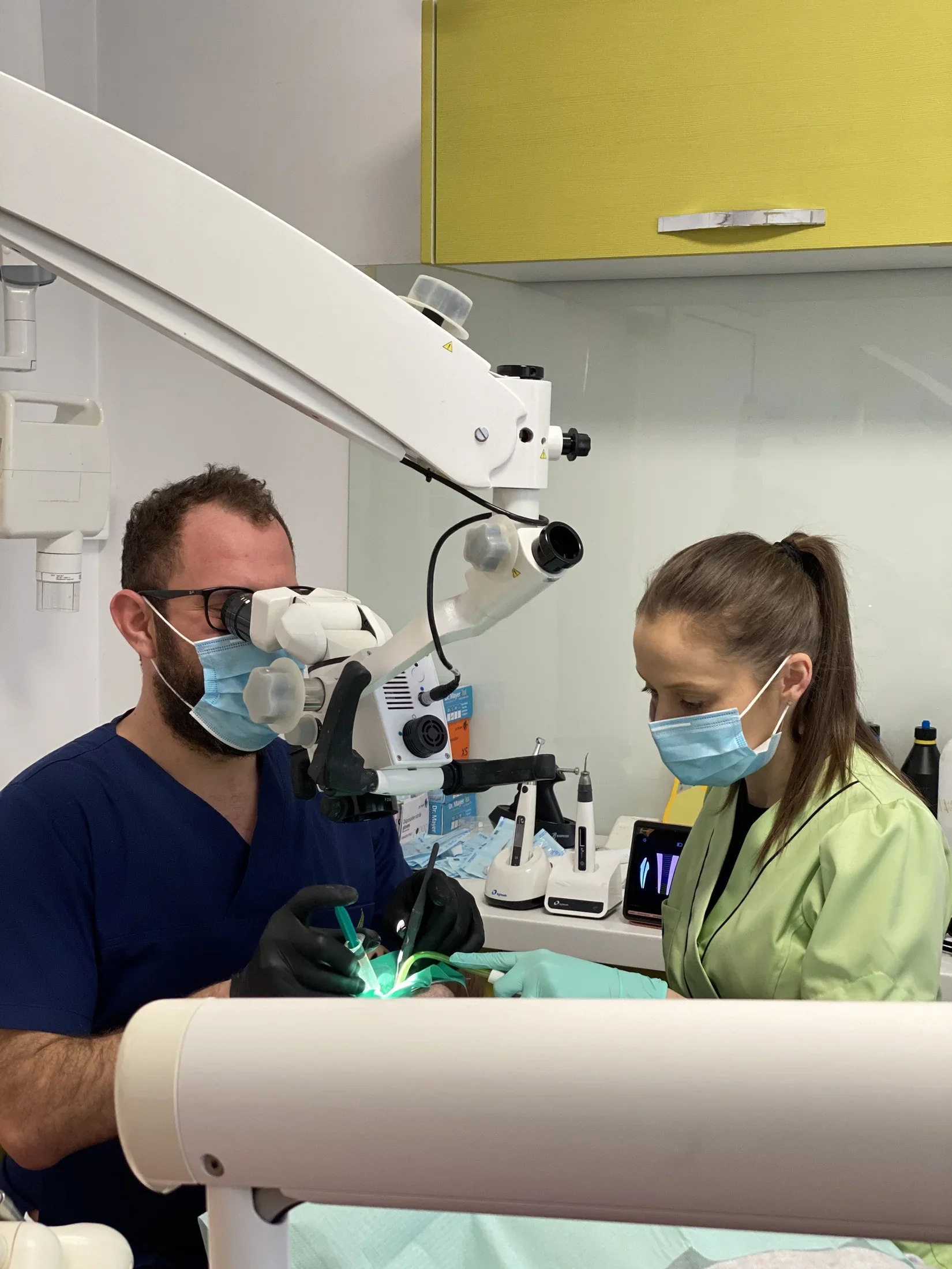 Medic realizând un tratament endodontic la microscop în clinica Uzina de Zâmbete